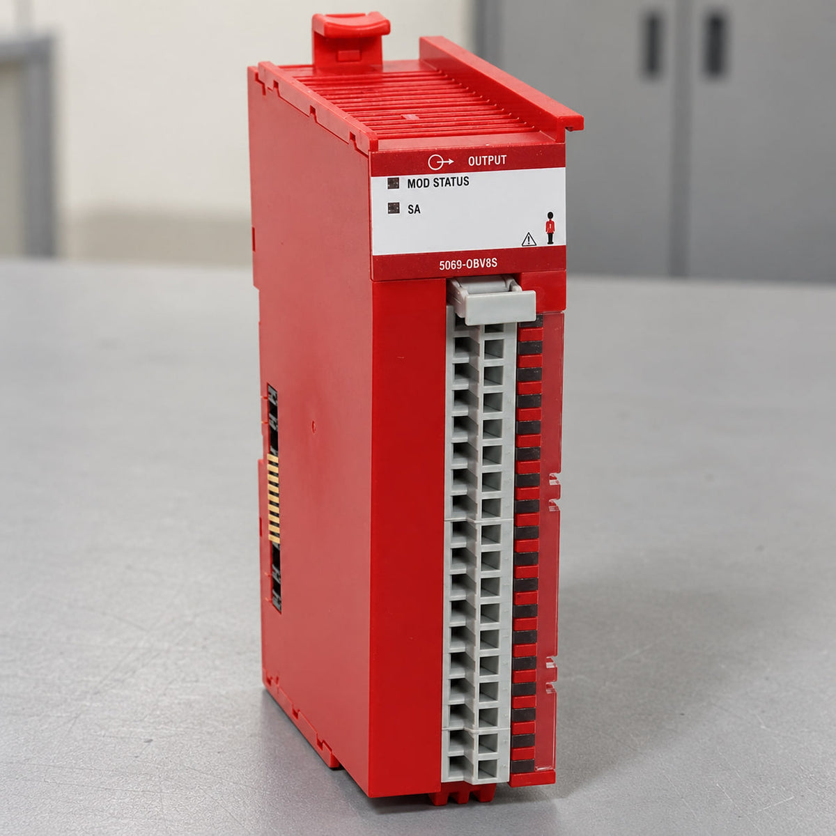 Allen-Bradley 5069-OBV8S safety output module standing on a workbench, faceplate and point lights visible