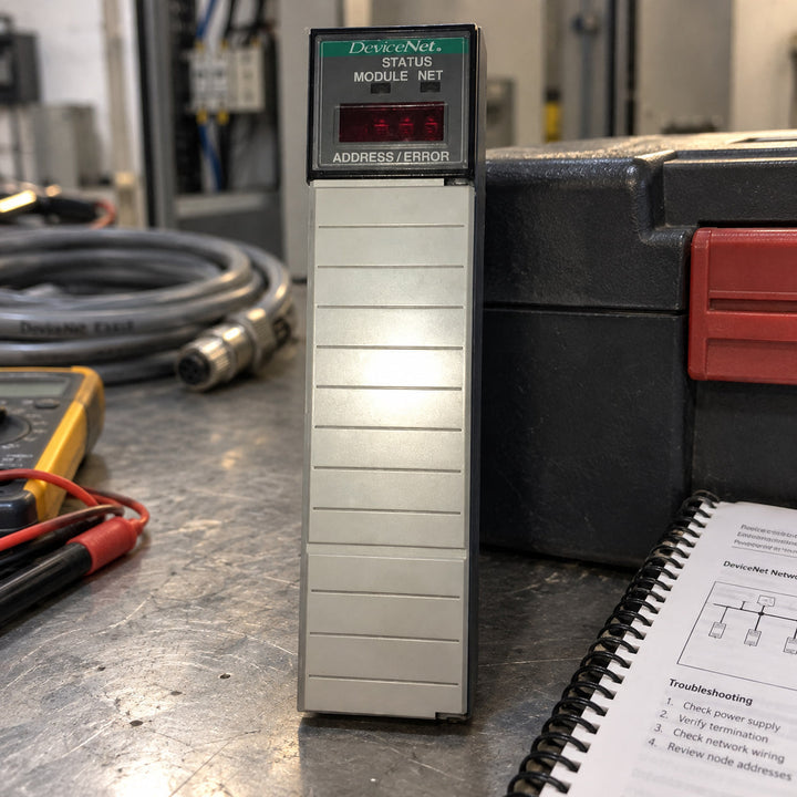 Allen-Bradley 1747-SDN DeviceNet scanner module on a workbench with a multimeter and cable
