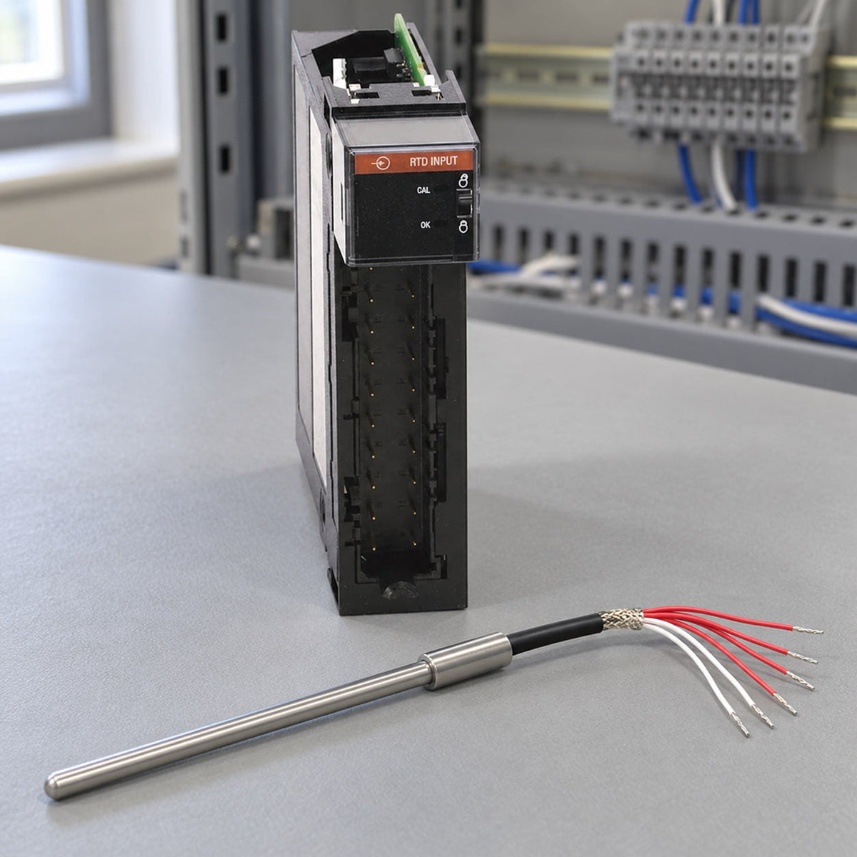 Six-lead dual element RTD probe lying next to a 1756-IR6I RTD input module