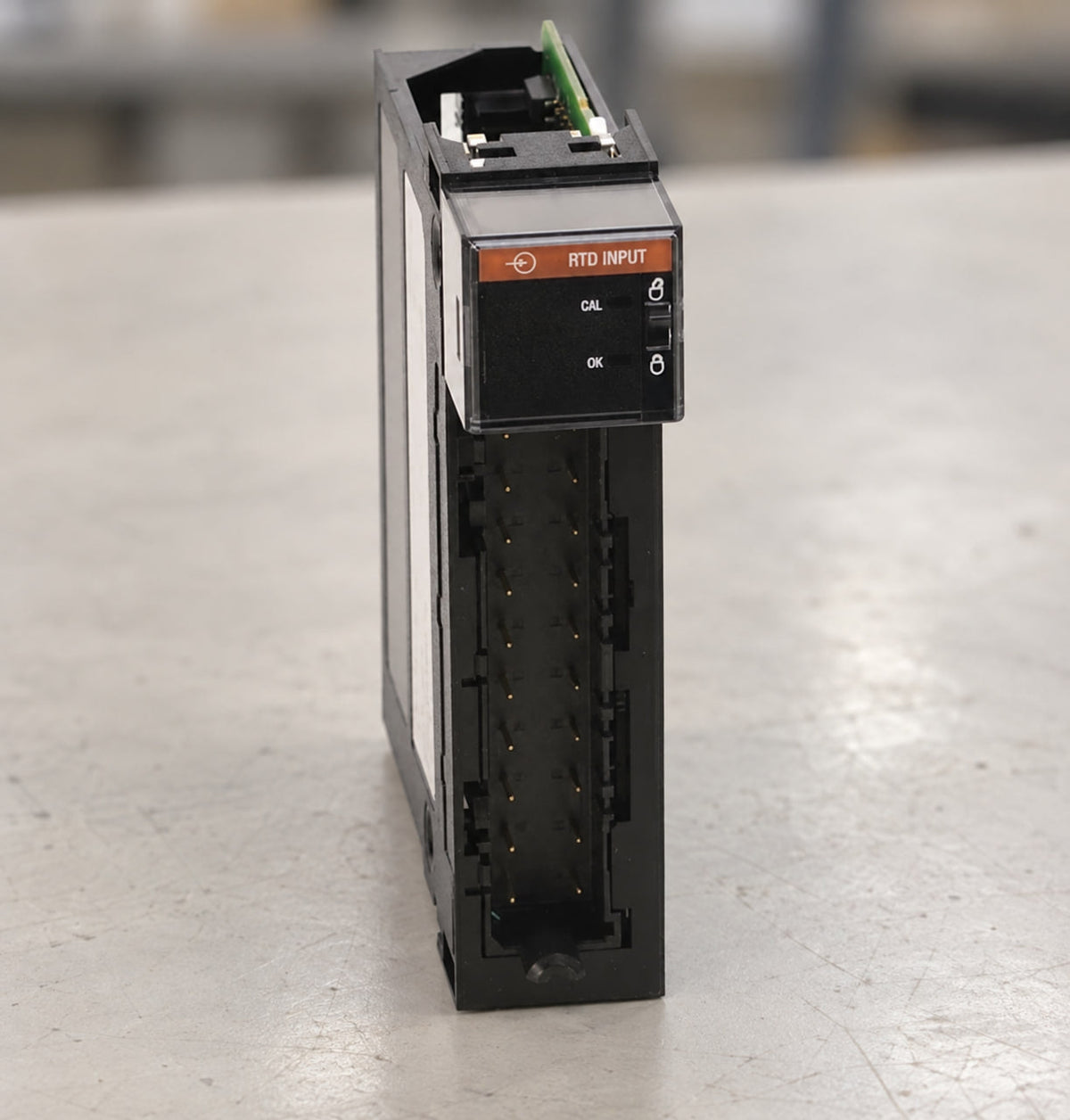 Allen-Bradley 1756-IR6I RTD input module resting on a workbench, showing its RTD INPUT label and connector