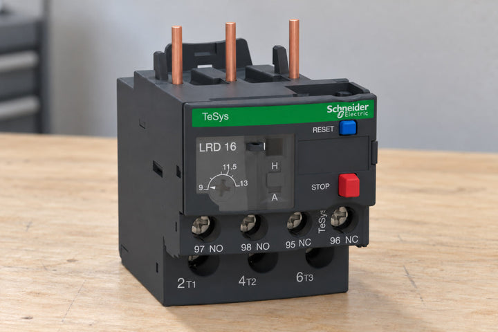 Schneider TeSys LRD16 thermal overload relay, 9-13 A range, standing on a workbench with its current-setting dial in view