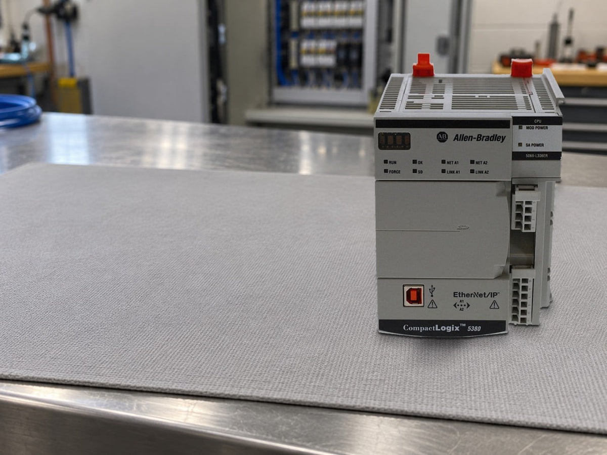 Allen-Bradley 5069-L306ER CompactLogix 5380 controller standing on an anti-static mat on a panel shop workbench